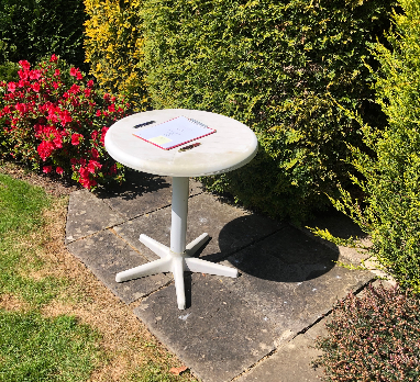 white table in garden with will and two pens